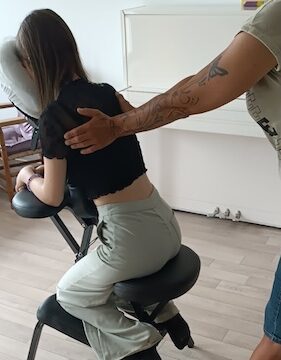 La thérapeute procède à un massage intuitif du dos et des épaules.